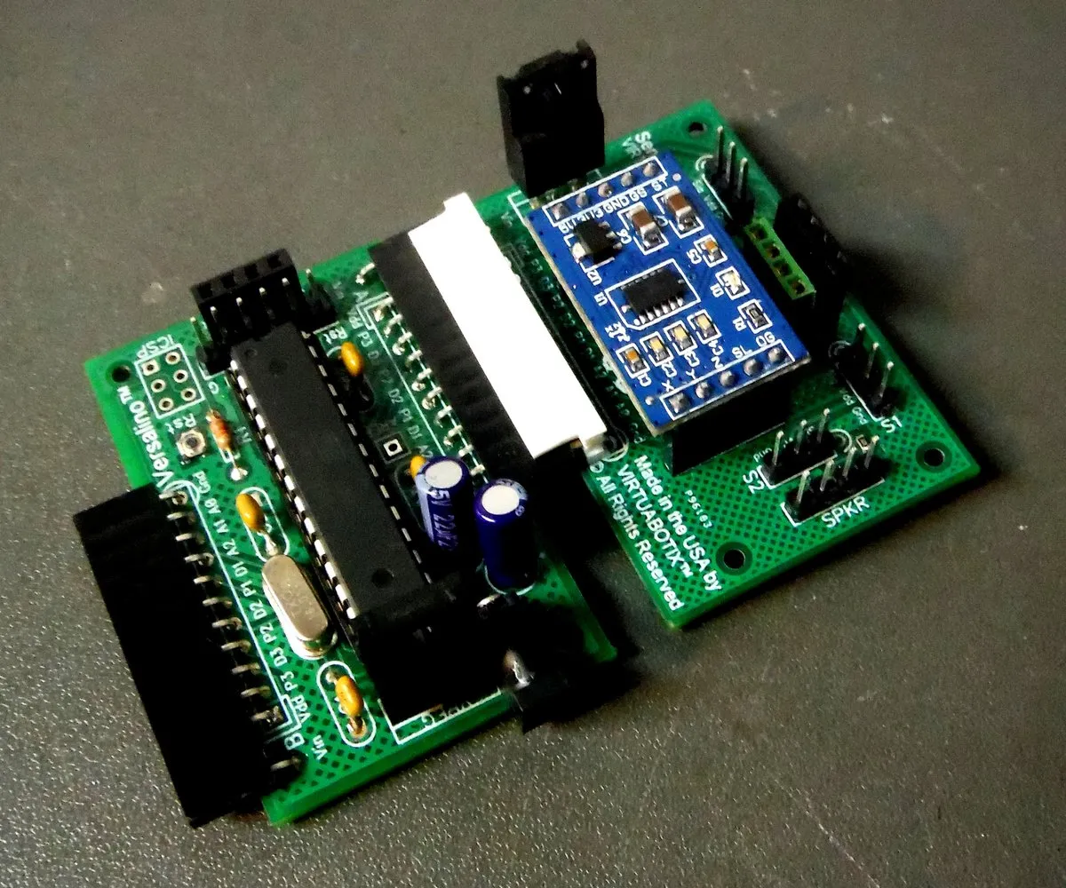 A Versalino Uno board with a blue Virtuabotix accelerometer module plugged in, resting on a gray surface.